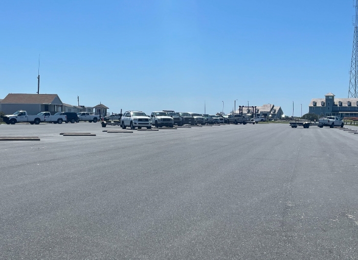 Oregon Inlet public boat ramp parking lot. Image of paved parking lot without lines.