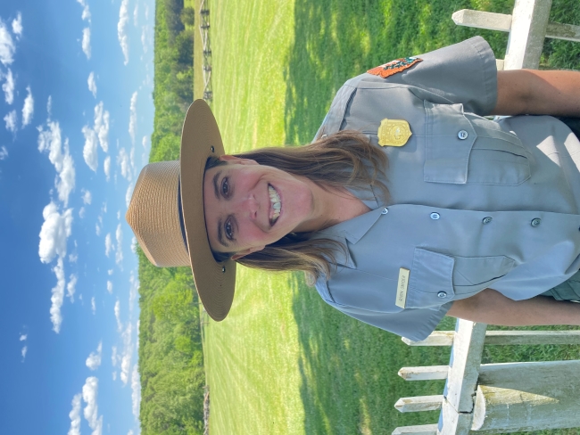 Photo of Robin Snyder in front of white fence and green scenery.