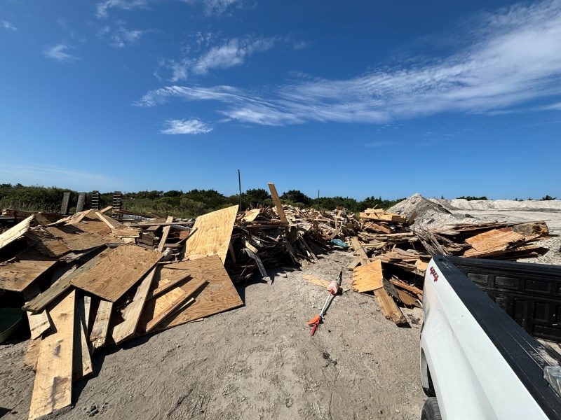 Photo of large piles of collected house collapse debris.