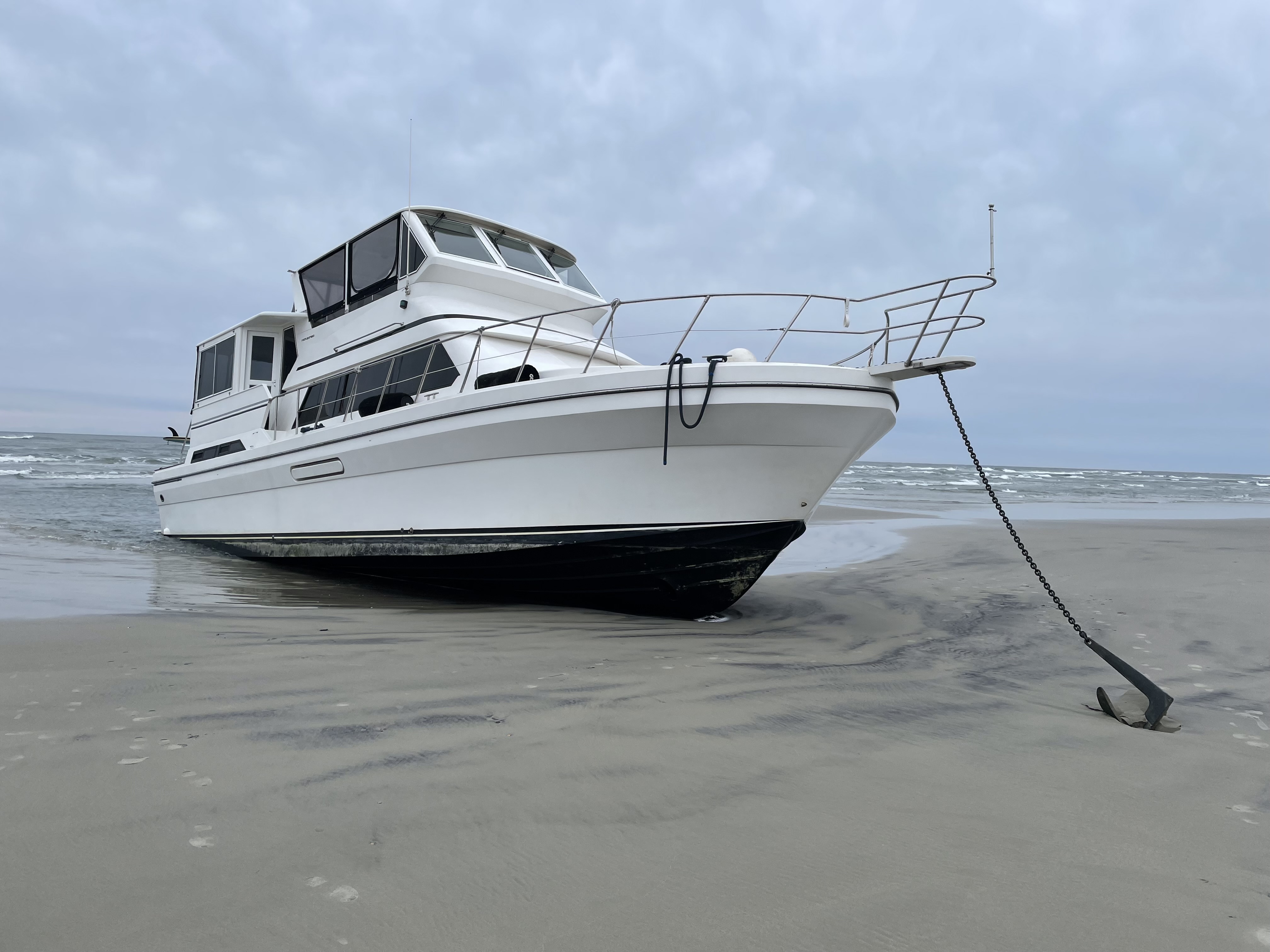 Vivens Aqua on the beach. Photo of a white yacht grounded on beach.