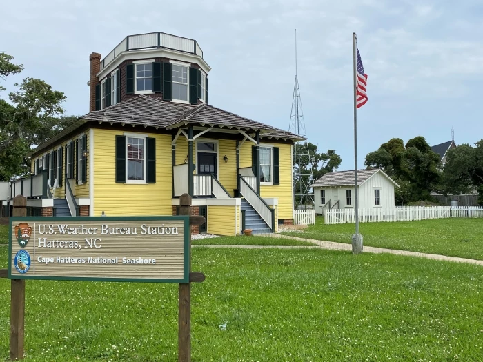 Weather Bureau Station sign, buildings, and weather tower Photo showing sign that says U.S. Weather Bureau Station, Hatteras, NC, along with buildings and a metal tower.