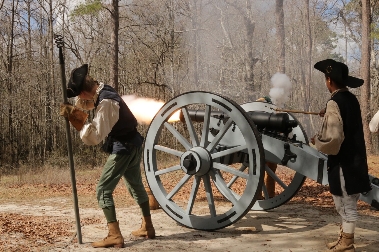 American Revolutionary War reenactors fire a cannon.