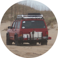 Vehicle driving down the beach.