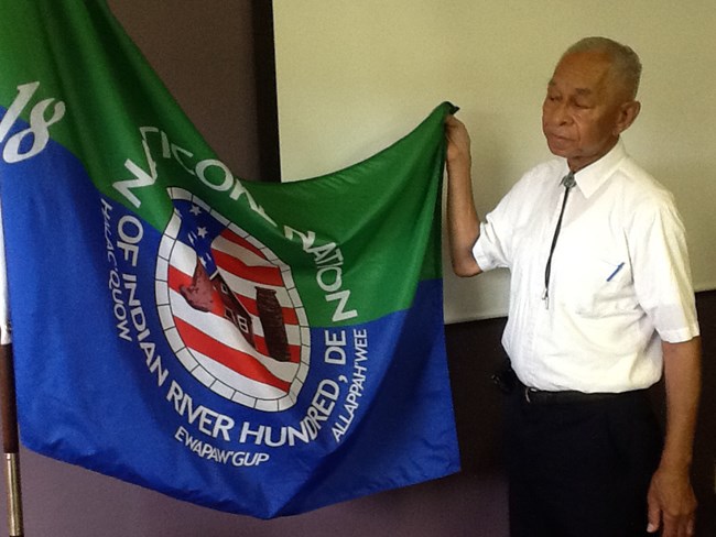 Chief William Daisey holds up the flag of the Nanticoke Indian Association