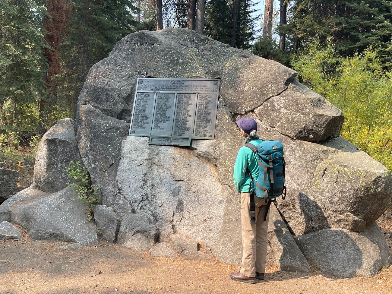 A large granite outcrop, about 10 feet high, gray with flecks of green moss.