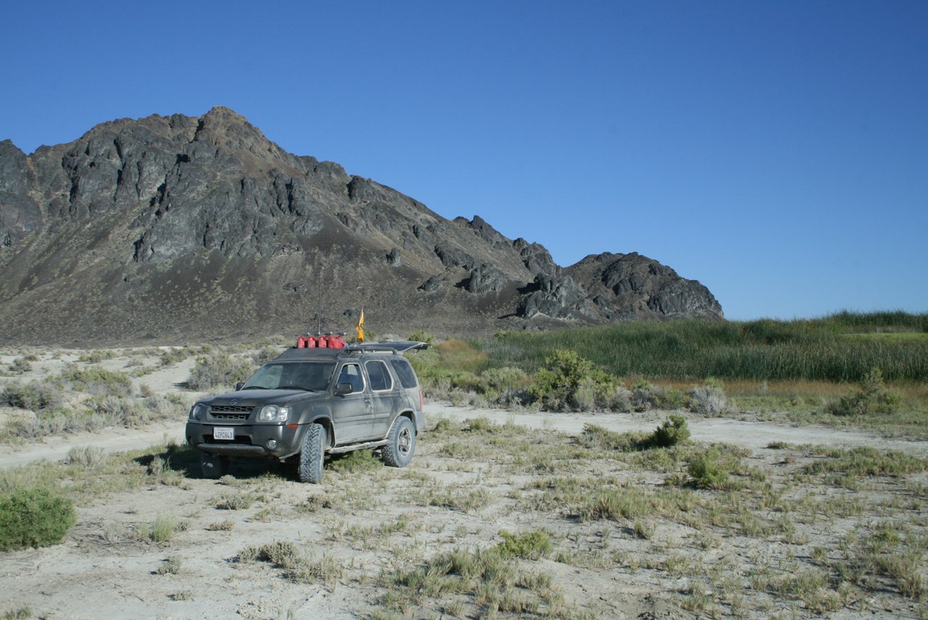 An SUV sits in a desert setting.