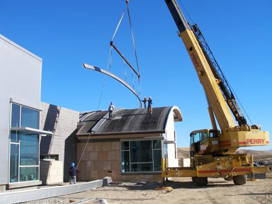 Hoisting metal roof panels to the roof of the Trail Center