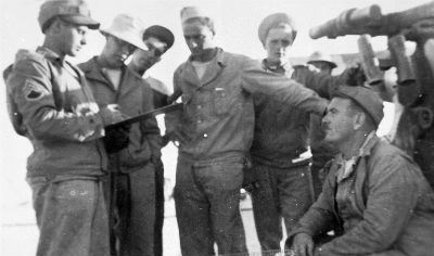 World War II era personnel look over a clipboard.