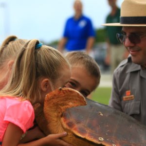 Children touch a sea turtle model during a ranger program.