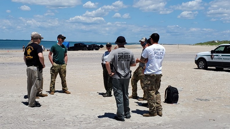 Members of the search team from various agencies gather together to discuss their next action in the search for missing person Enrique Roman-Martinez