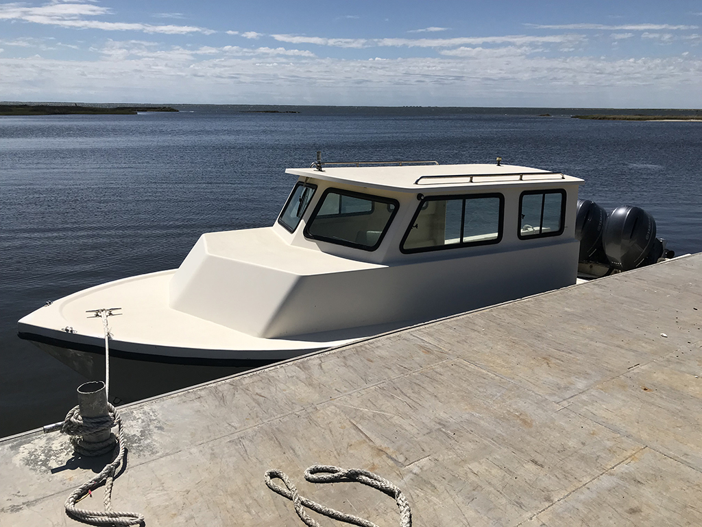 NPS boat tied to the Lola dock where the theft of items occurred white boat with cabin sits in water next to dock and tied to the dock