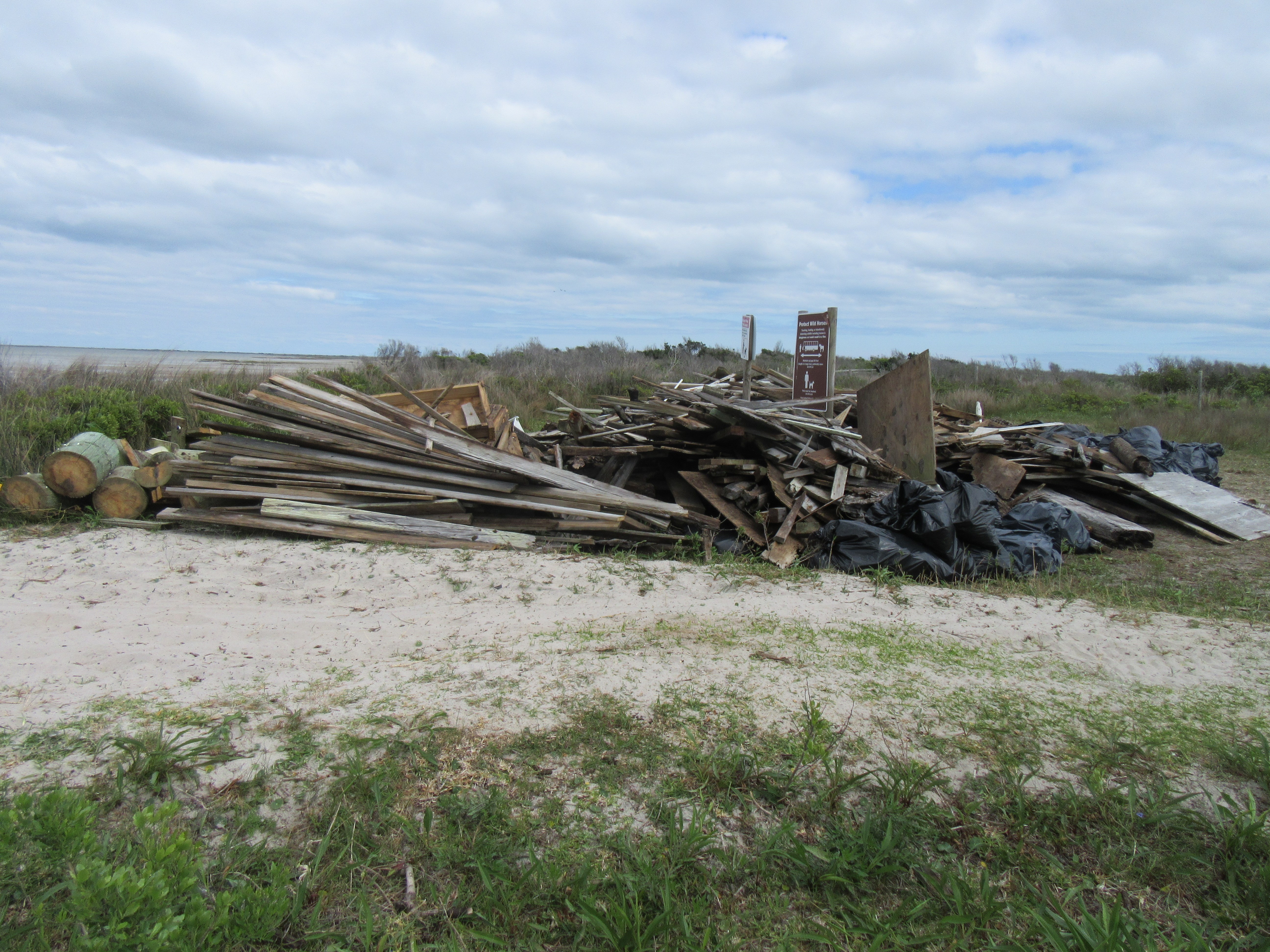mid-island debris pile awaiting removal from Shackleford Banks large pile of boards and other debris