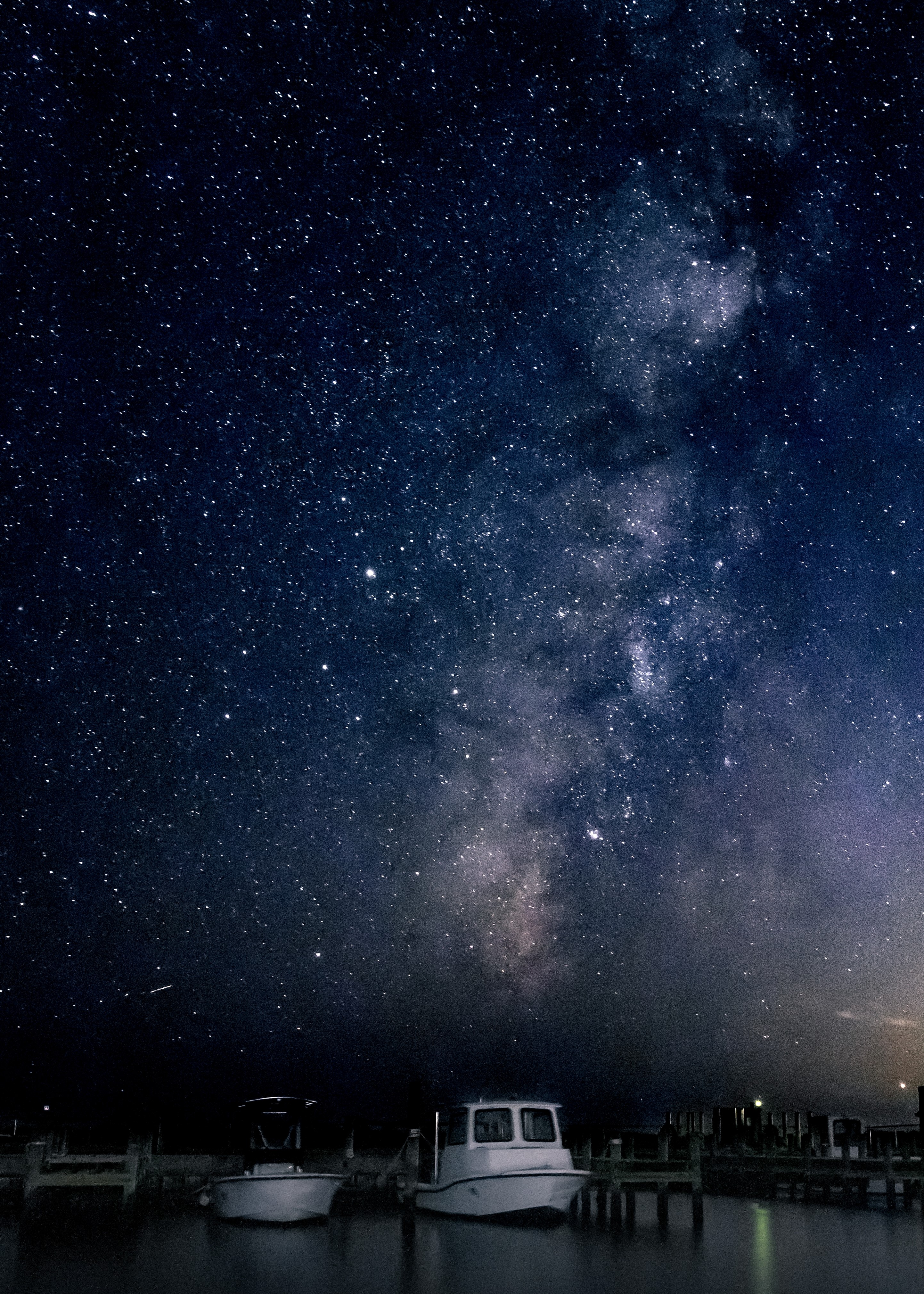 Milky Way over boats in harbor