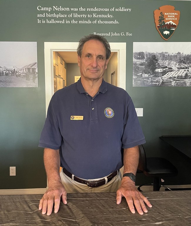 A Volunteer standing at an information desk.