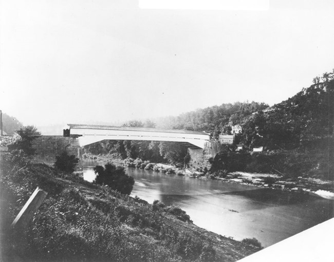 Wooden covered bridge over river at the time of the Civil War.