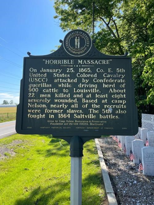 Memorial marker describing Simpsonville Massacre with gravestones on right.
