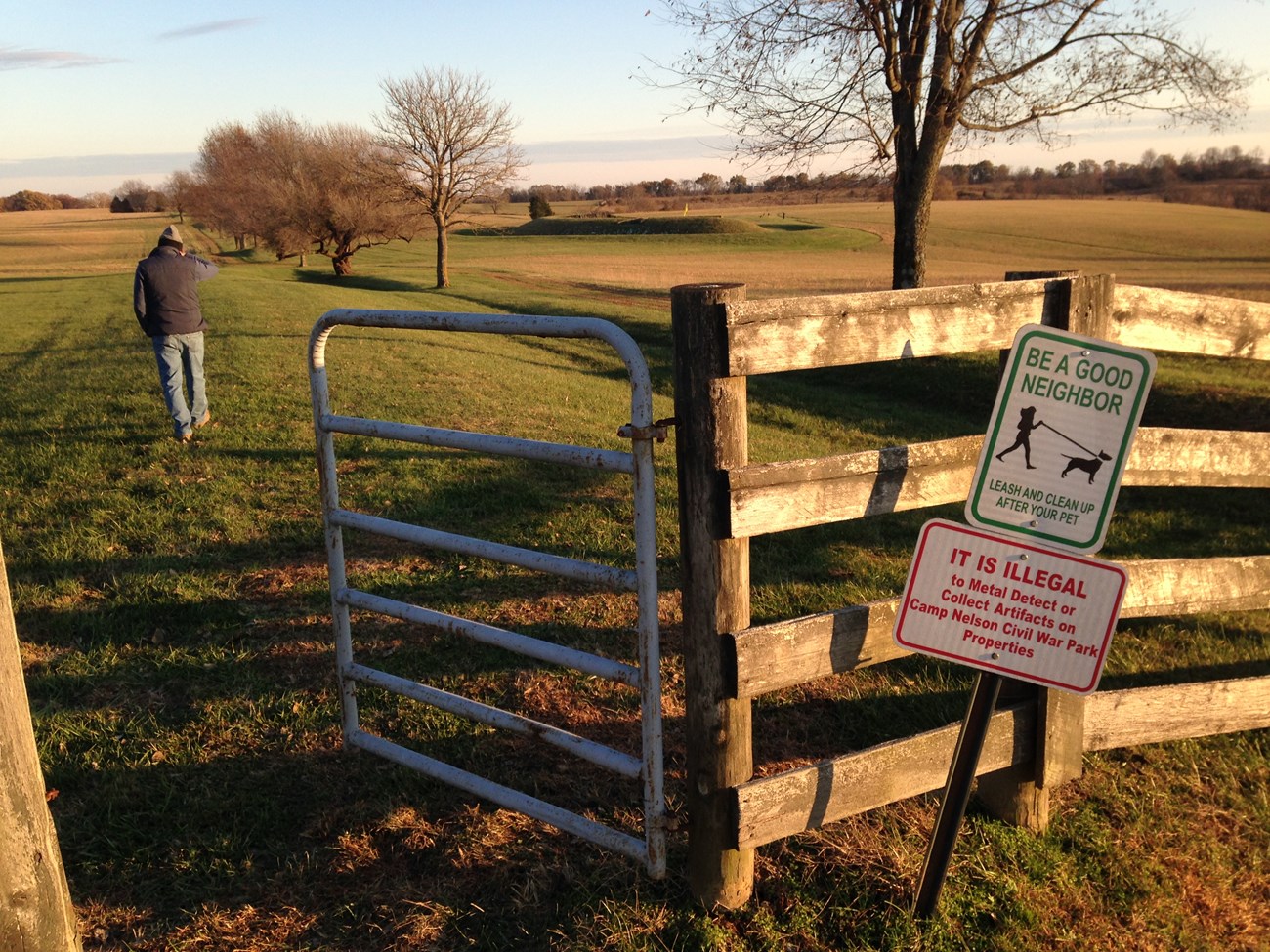 Man walks through gate with posted regulation signage