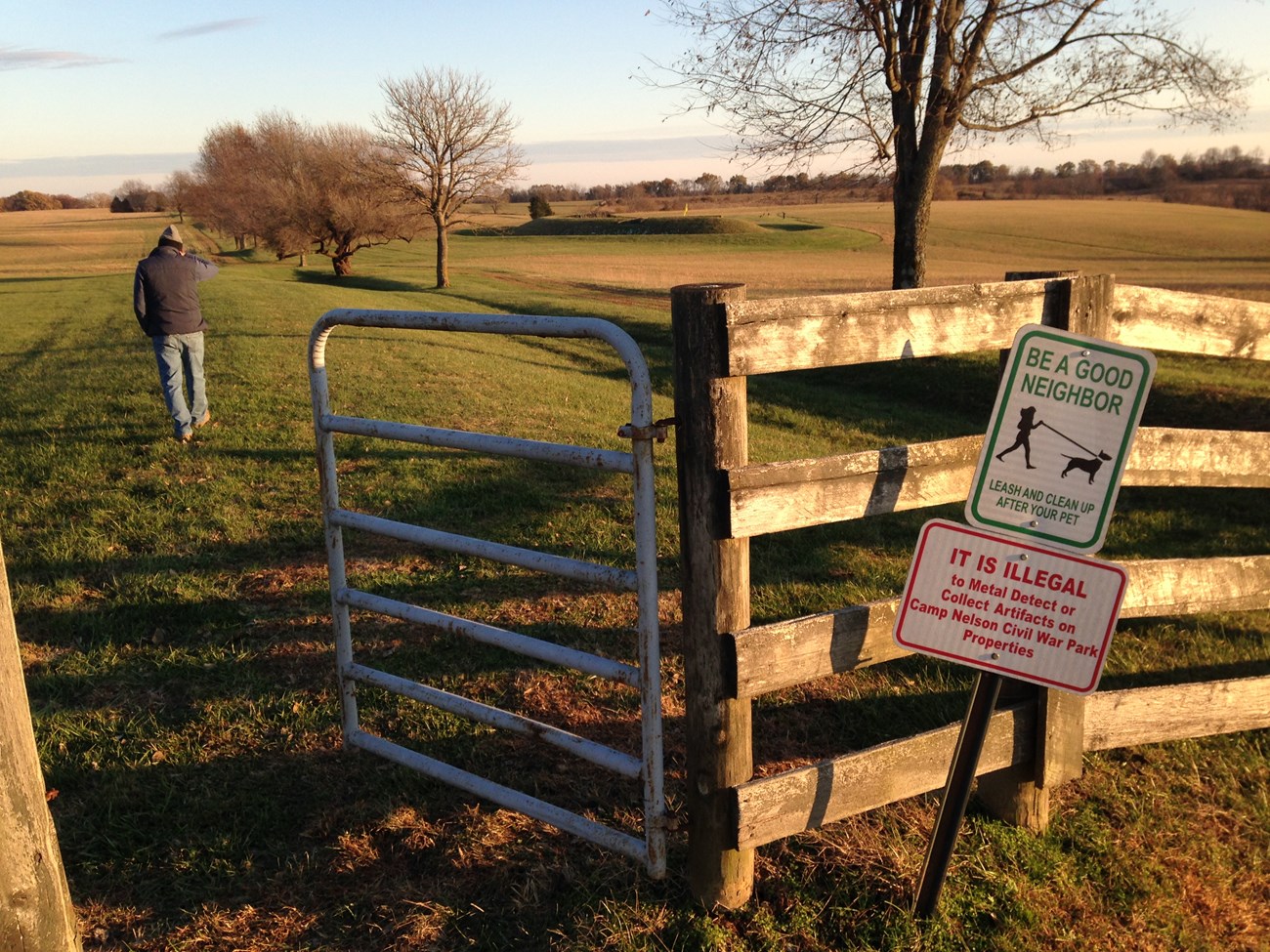 Man walks through gate with posted regulation signage