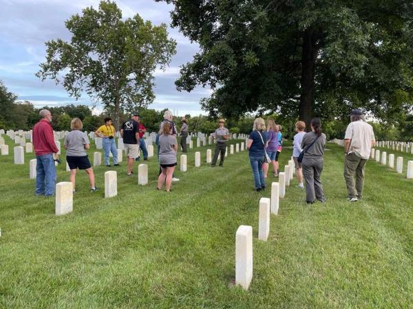 History at Sunset, July 30, 2022 Group of people standing in cemetery listening to park ranger speak
