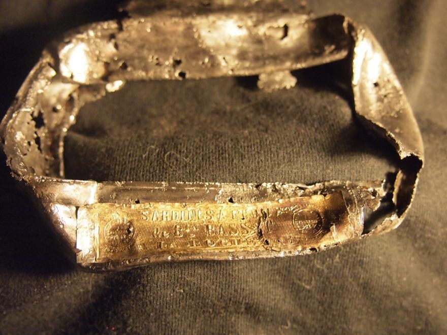 A tin sardine can on a black mat