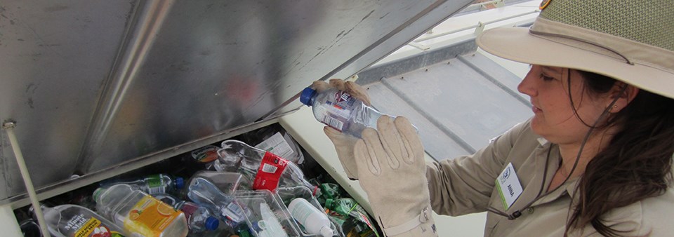 a woman puts plastic bottles into a recycling container a woman puts plastic bottles into a recycling container