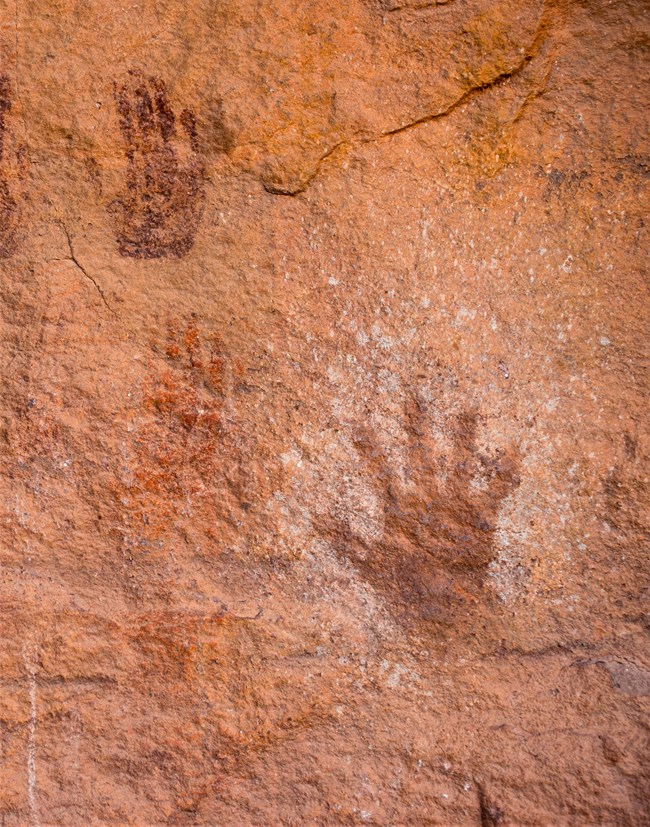 Outline of hands on a sandstone wall