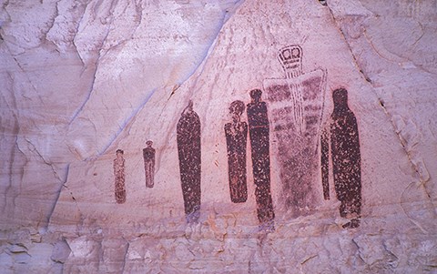 several human-shaped figures on a rock wall