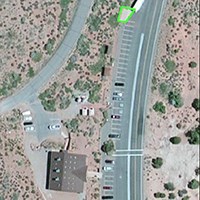 a satellite image of a building with a green outline at the end of the parking lot.