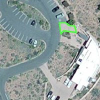 a satellite image of a building with a green outlined area next to it