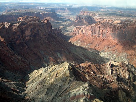 red and white folded rock layers in a crater