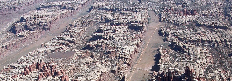 An aerial view of rocky cliffs with flat valleys in between