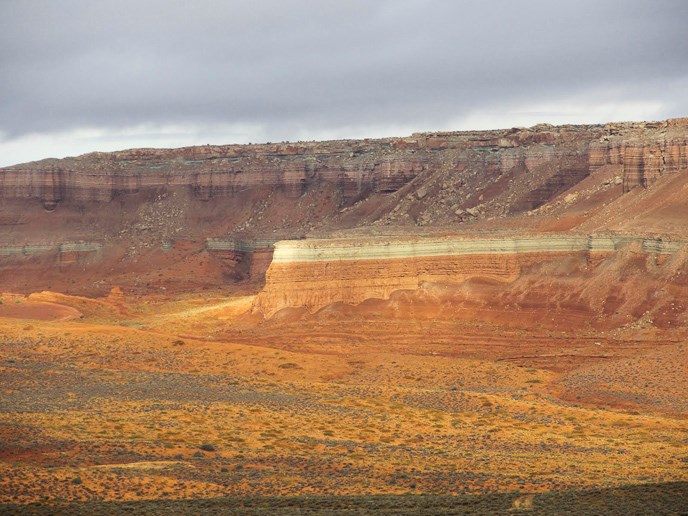 The light-colored, grayish-green layer in the middle of the escarpment is the Curtis Formation (below the Sommerville).