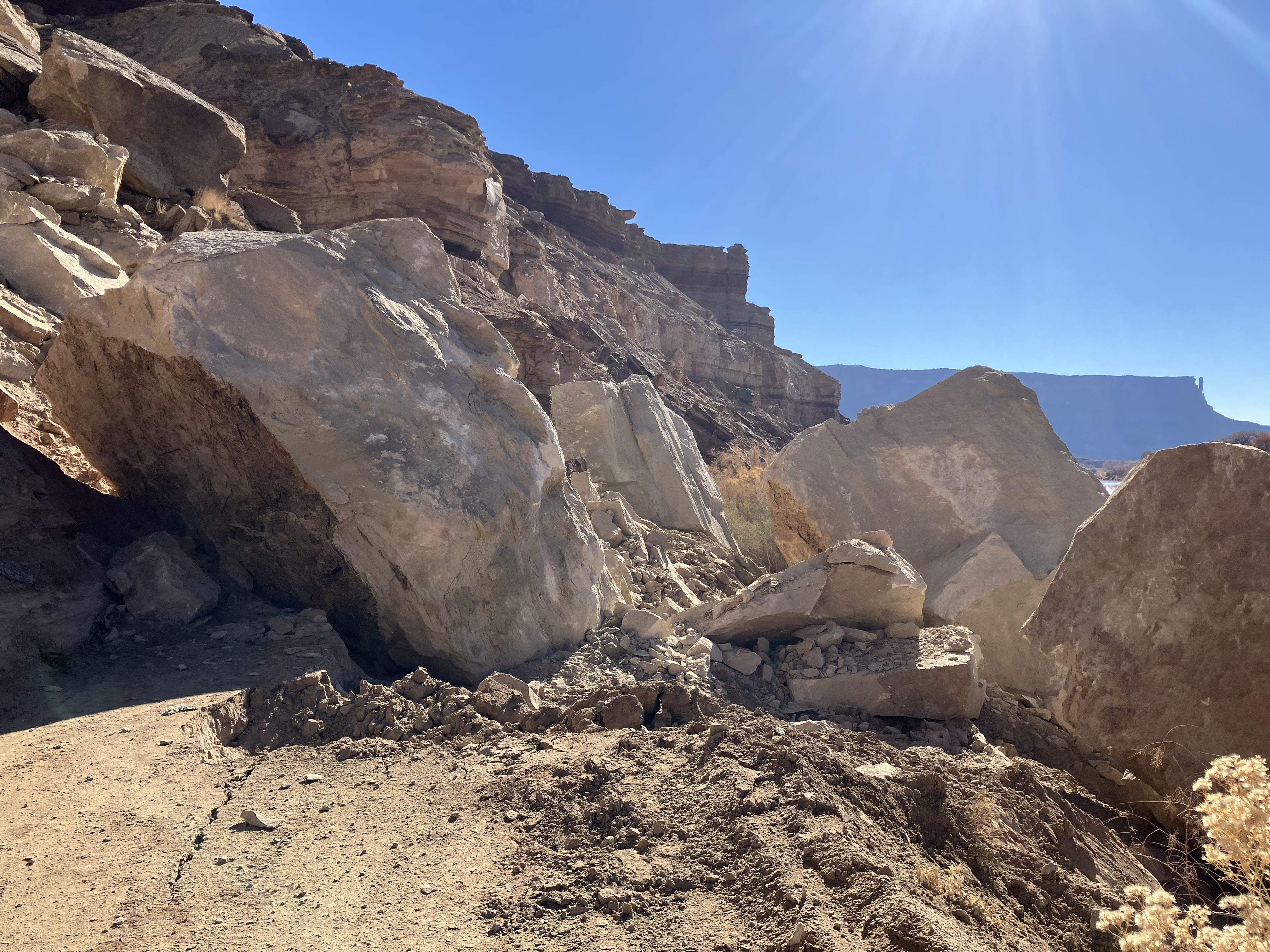 sandstone boulders and smaller rocks cover unpaved roadway