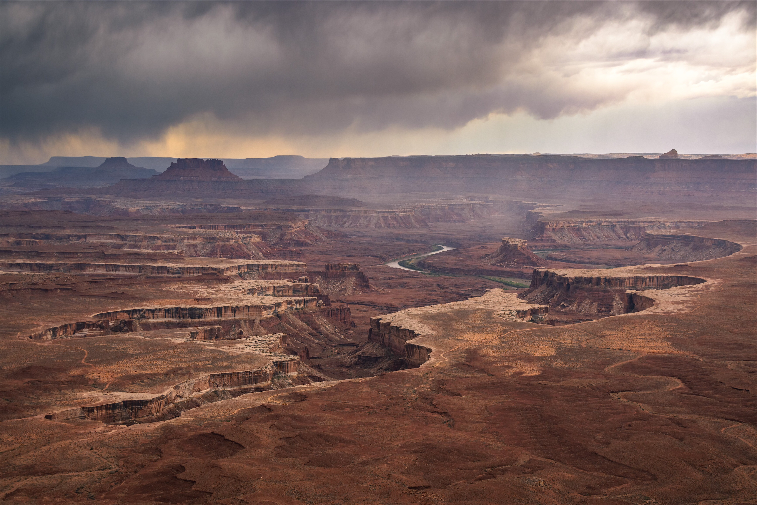 Misty clouds surround the canyons visible from green river overlook on a rainy day.