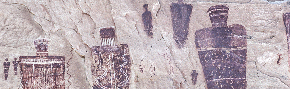 Brown human-like figures on a rock face Brown human-like figures on a rock face