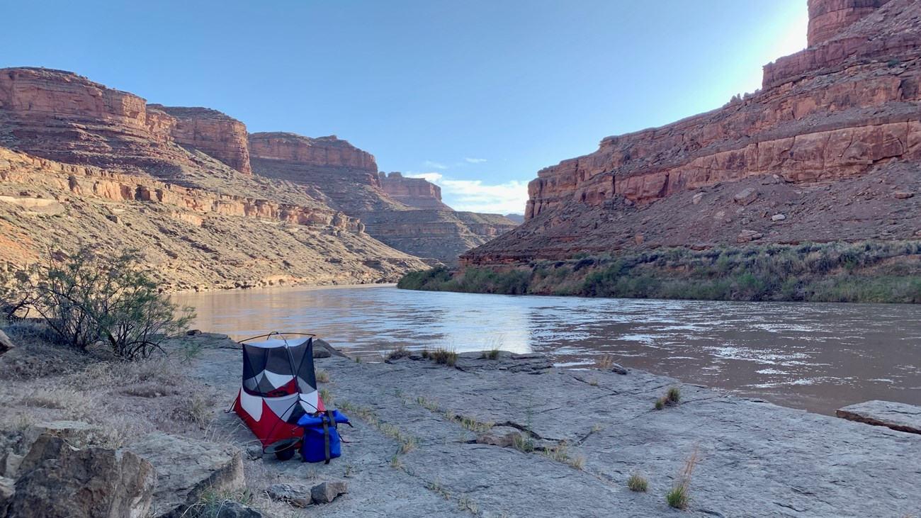 Tent set up on rock ledges along a river