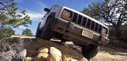 a jeep driving over a pile of rocks