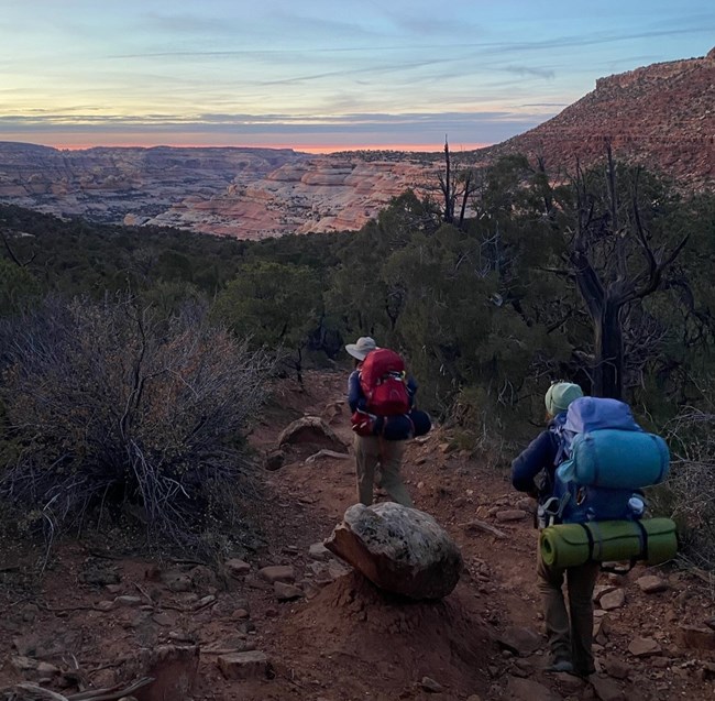Two backpackers hiking at sunrise