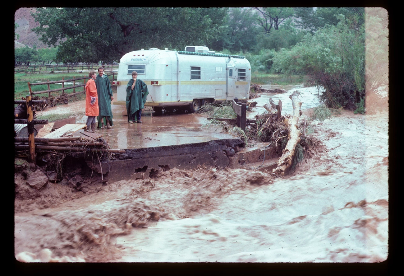 Fremont River Flash Flood July 1985 Visitors in ponchos in front of an RV as a flash flood roars across a collapsed road in front of them