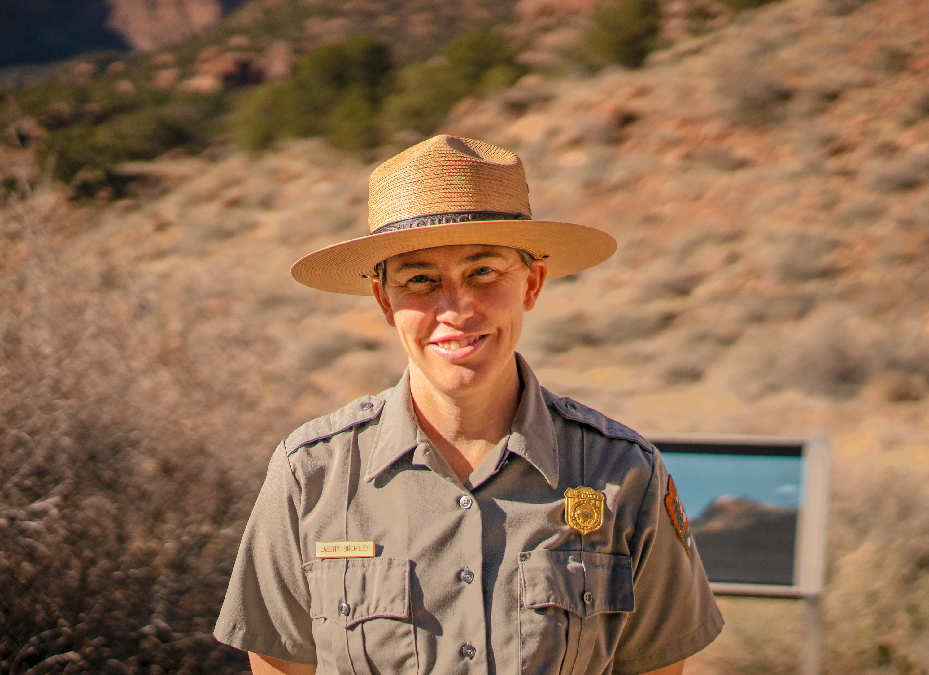 Cass Bromley Photo of Superintendent Cass Bromley in NPS ranger uniform outside with a desert landscape in the background.