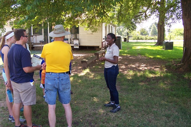 HBCUI Intern Daysha Brown talks with visitors outside the Oakland Plantation Store.