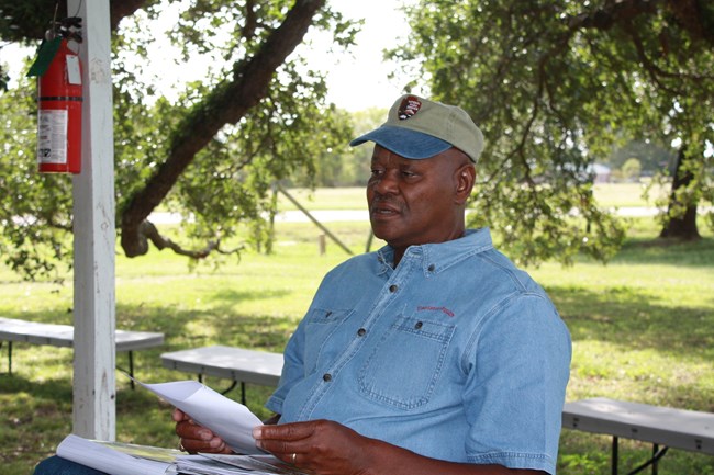 Elvin Shields sitting on the porch of the cabin.