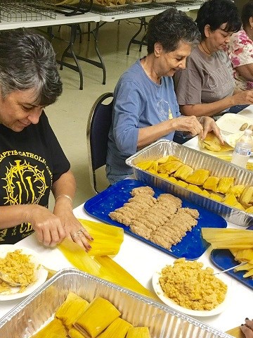Creole women sit around a table making tamales.