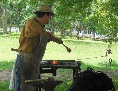 Blacksmith heats metal over a fire