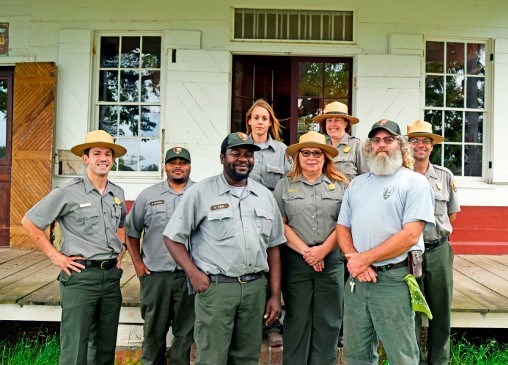 Park rangers posed in front of historic store.