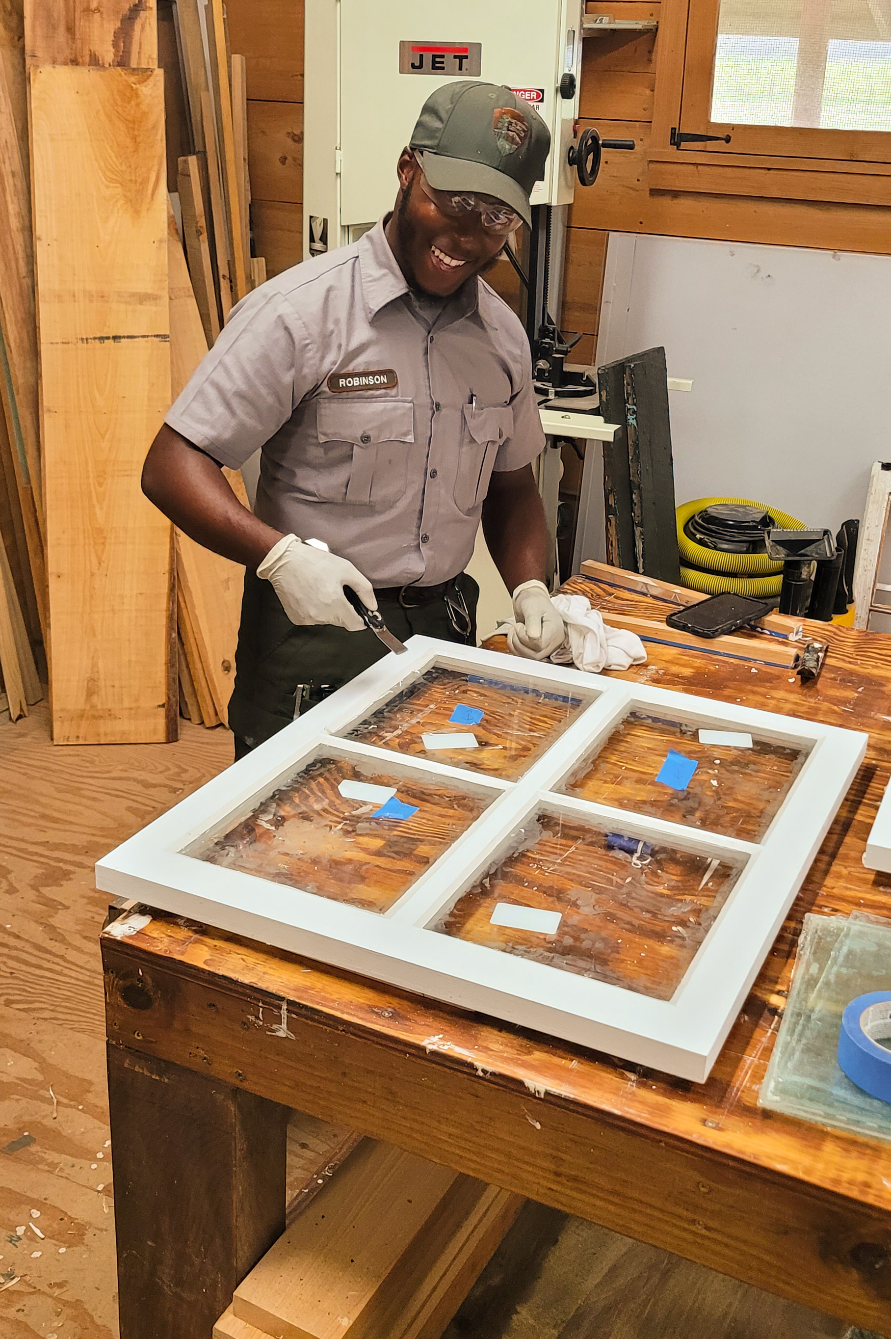 A member of the Maintenance Action Team glazing a window.