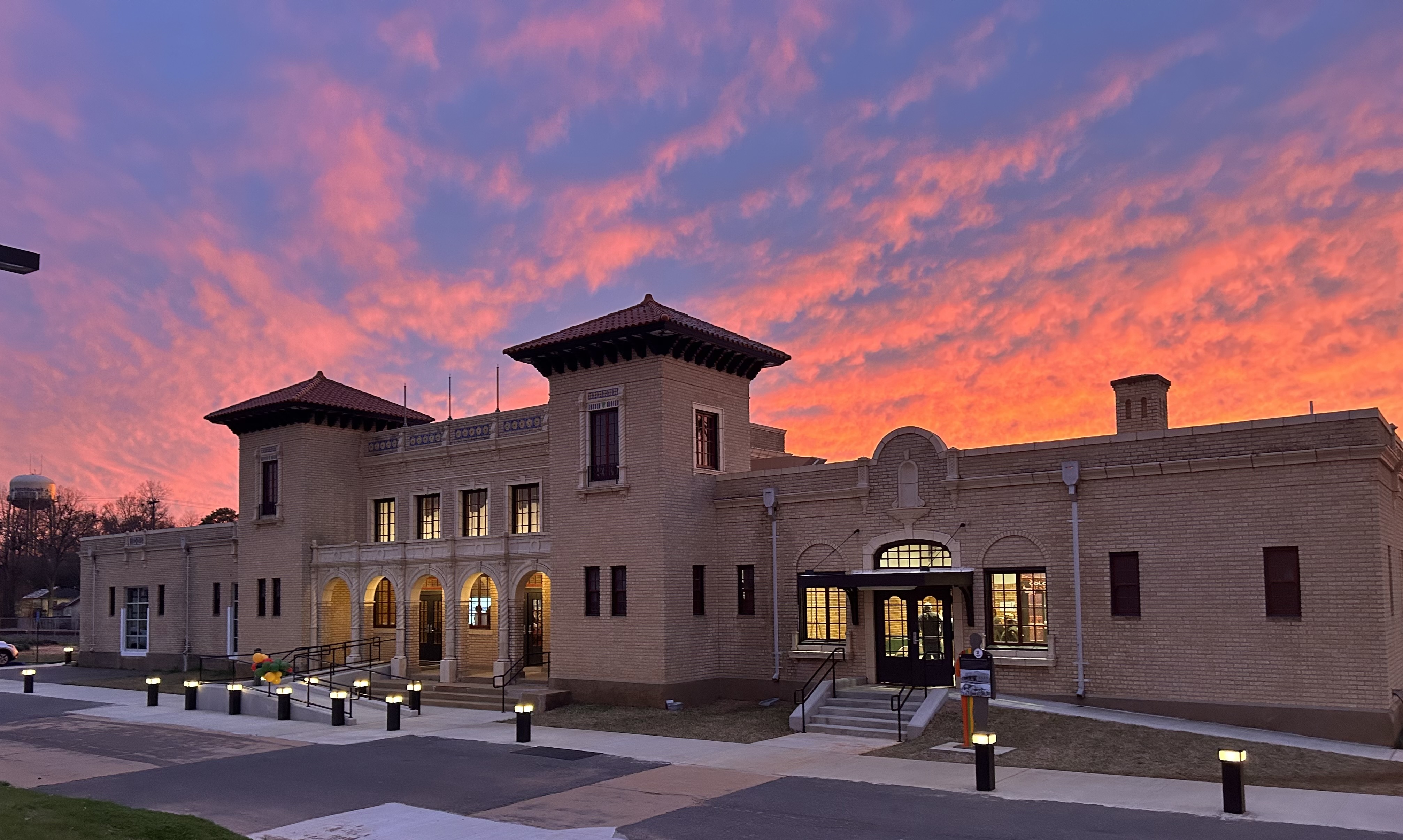 The Texas and Pacific Railway Depot A yellow brick building with twin towers at sunset.