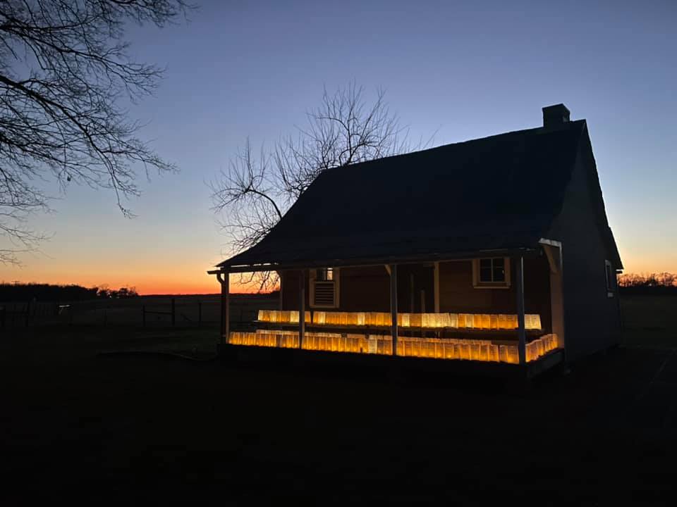 2021 memorial illumination at Oakland Plantation Rows of luminarias line the porch of an Oakland Plantation Cabin.