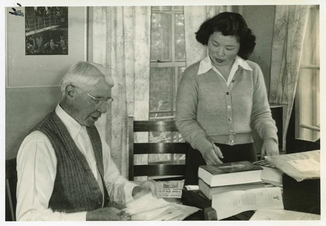 black and white image of a woman standing next to a man