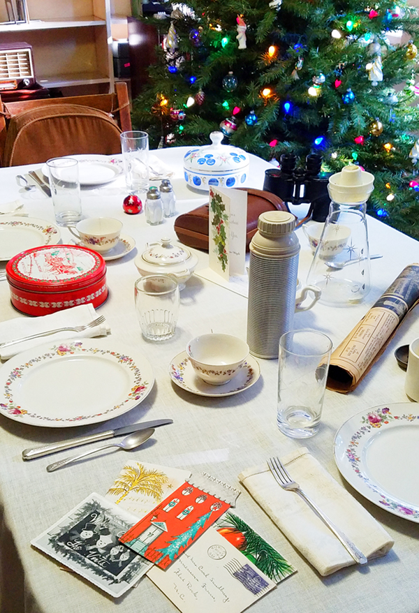 Dining room table in the Sandburg Home set for a meal decorated with Christmas tins and cards.